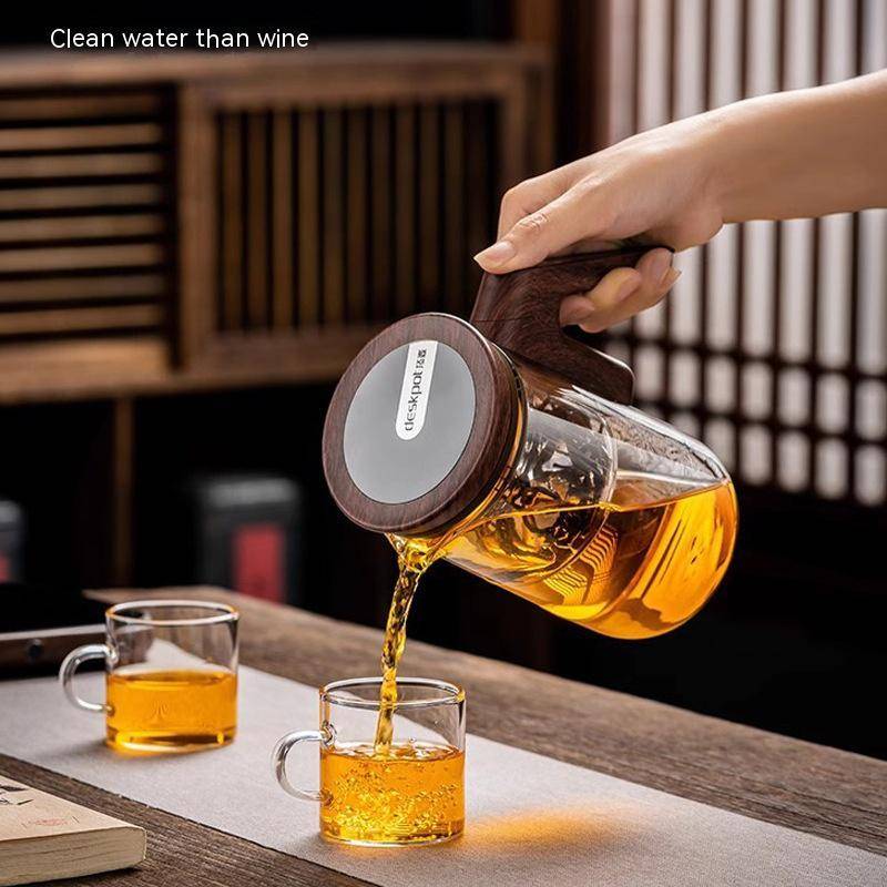 Glass tea pot with intelligent timing and automatic filter, pouring freshly brewed tea into an elegant cup. Designed with a full glass liner for precision brewing.