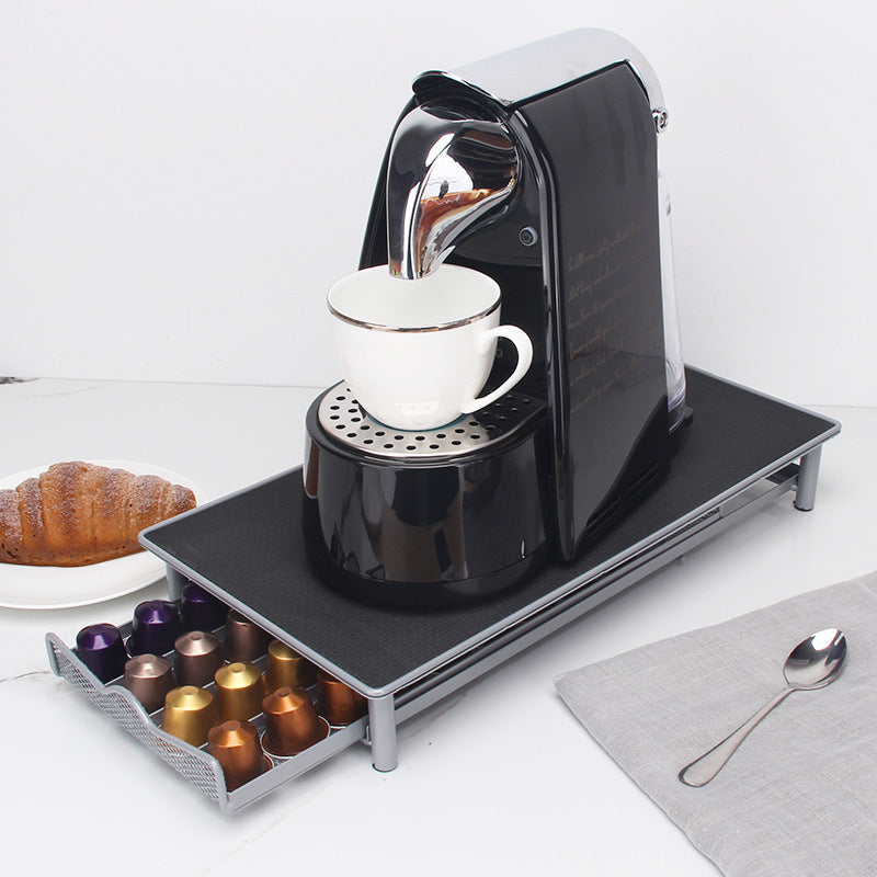 a coffee maker on a tray with a cup of coffee