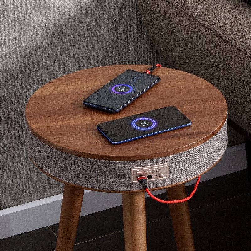 Bluetooth speaker coffee table with wireless charging in use, charging two smartphones. A stylish and practical addition to any smart home setup.