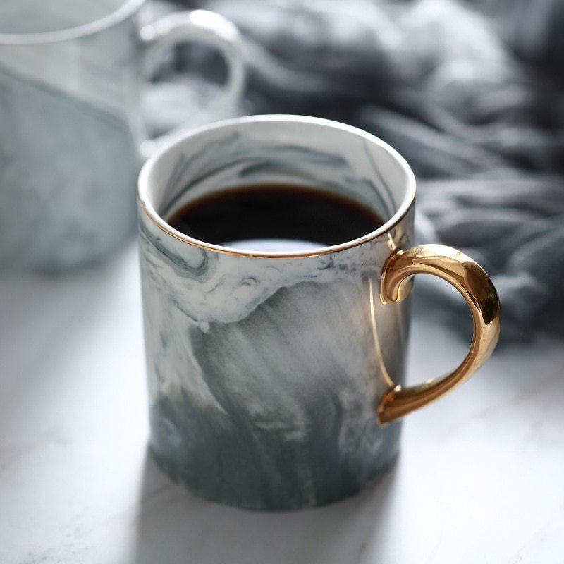 Creative Ceramic Mug with Marble Pattern and Gold Handle on a table