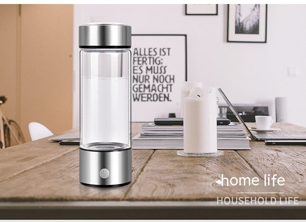 Modern silver hydrogen water bottle on a wooden table in a home setting. Electric and rechargeable, providing hydrogen-rich water for daily wellness.