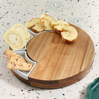 Wooden cheese board with compartments containing bread slices and a roll on a speckled countertop.