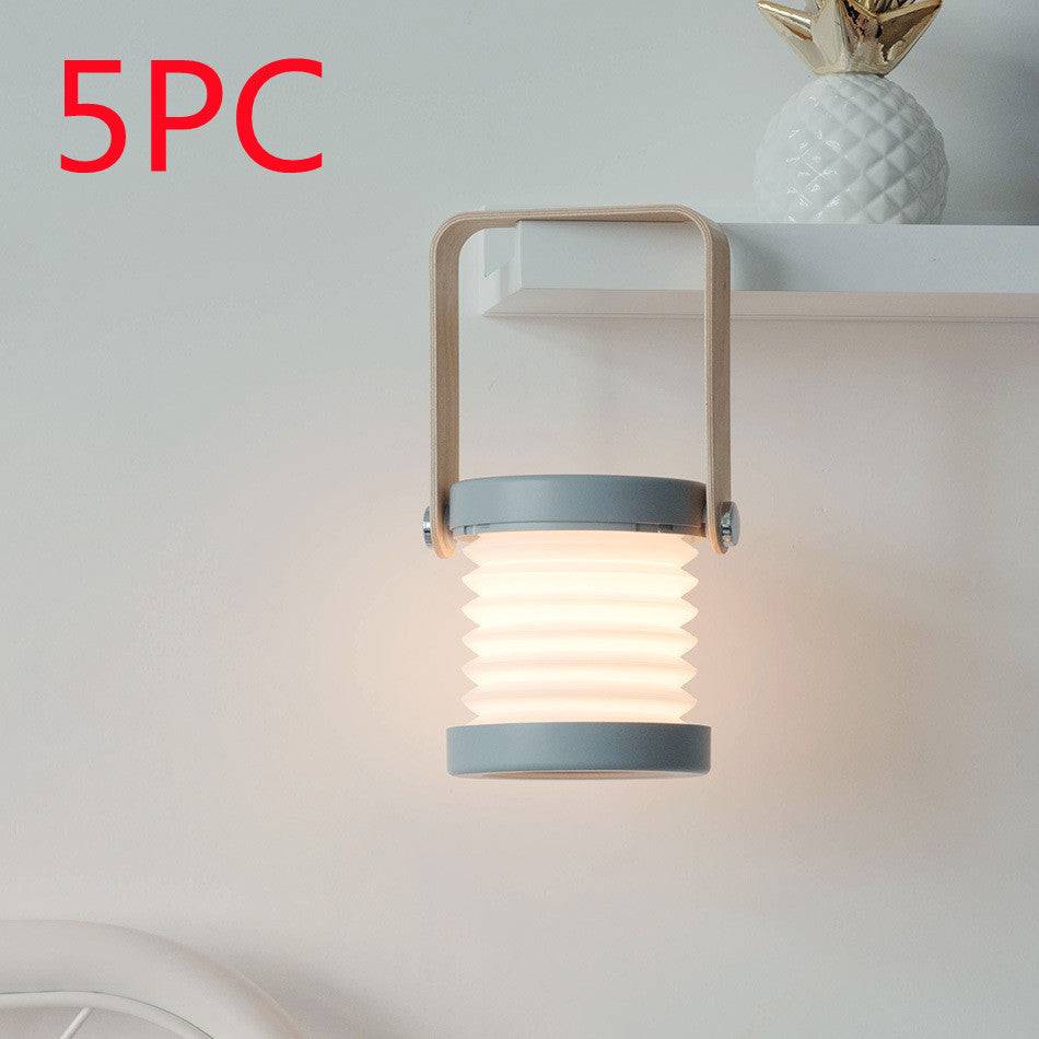 Set of five foldable LED night lights mounted on a shelf. USB rechargeable lantern with touch dimmable brightness for modern interiors.