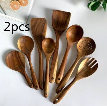 Teak wood kitchen set from Thailand featuring spoons, ladles, and turners in a glass measuring cup. Durable and eco-friendly tableware for cooking.