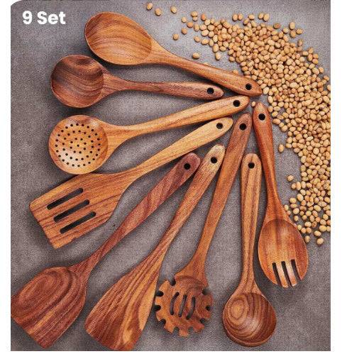 Teak wood kitchen set from Thailand featuring spoons, ladles, and turners in a glass measuring cup. Durable and eco-friendly tableware for cooking.