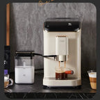 Coffee machine with milk frother and cup on a dark surface