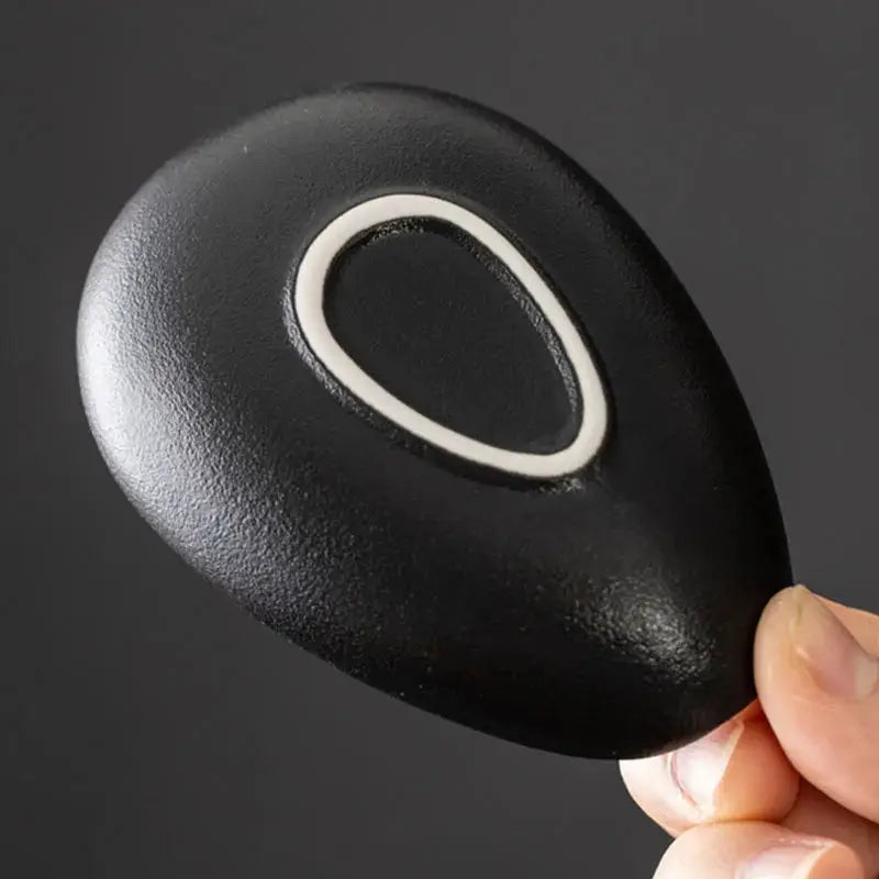 Black ceramic coffee beans dosing cup with a unique curved design and tapered spout for precise pouring. Ideal for espresso and coffee bean measuring.