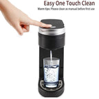 Electric travel coffee maker in black, with a hand pressing the easy clean button, water dispensing into a glass.