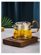 100°C Cup Heater Mug Warmer with automatic power-off, shown warming tea in a glass teapot on a wooden heating pad, ideal for hot beverages.