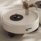 Round white coffee table with decorative items on a neutral background
