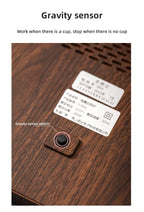 100°C Cup Heater Mug Warmer with automatic power-off, shown warming tea in a glass teapot on a wooden heating pad, ideal for hot beverages.