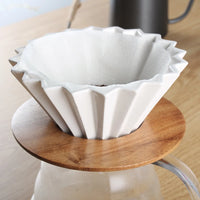 Elegant ceramic coffee dripper on a wooden countertop"