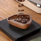 Wooden bowl filled with coffee beans on a digital scale