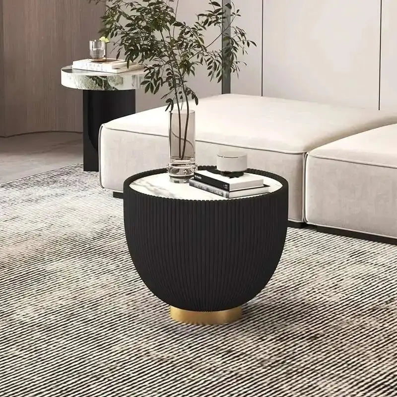 Modern black side table with gold base in a living room setting
