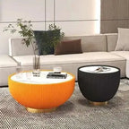 Modern living room with a gray sofa, orange and black side tables, and decorative items.
