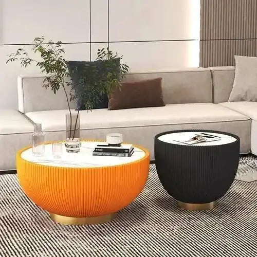 Modern living room with a gray sofa, orange and black side tables, and decorative items.