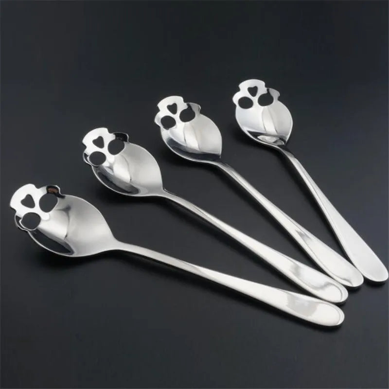 Four stainless steel skull spoons with a polished finish, featuring a unique cutout design. Ideal for coffee, tea, and dessert lovers.