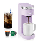 Electric travel coffee maker in lavender color brewing coffee into a white mug, accompanied by coffee capsules and an iced coffee drink.