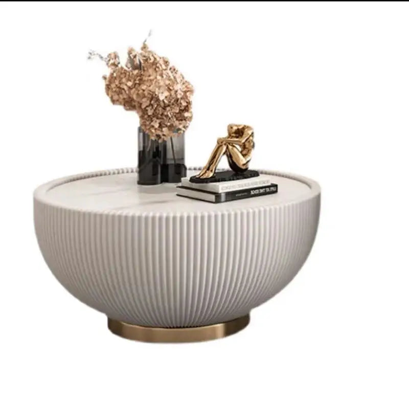 Round white coffee table with decorative items on a white background