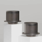 Two TIMEMORE SimpleDrip Water Droppers displayed on white pedestals, highlighting their sleek and modern design.