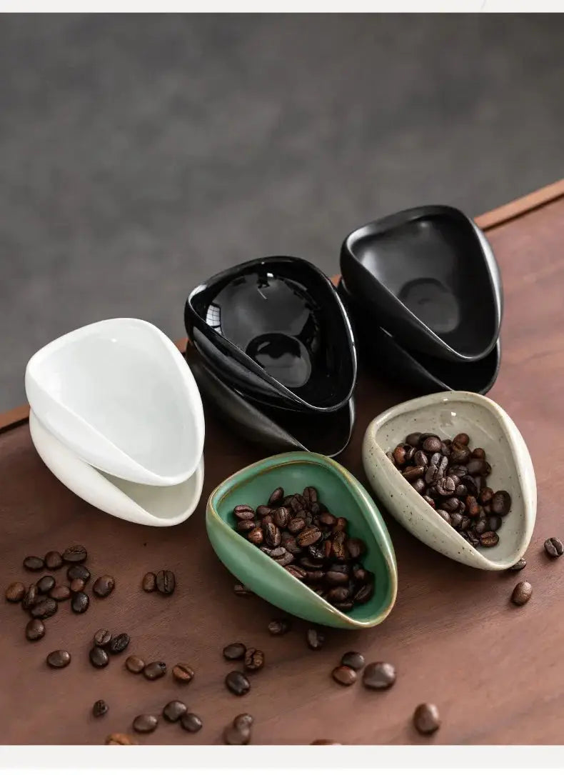 Ceramic coffee beans dosing cup with a speckled glaze finish, featuring a tapered spout for precise pouring. Ideal for measuring espresso beans with accuracy.