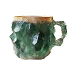 Colorful mineral crystal coffee mug in green resin, featuring an irregular shape and a textured handle for a comfortable grip.