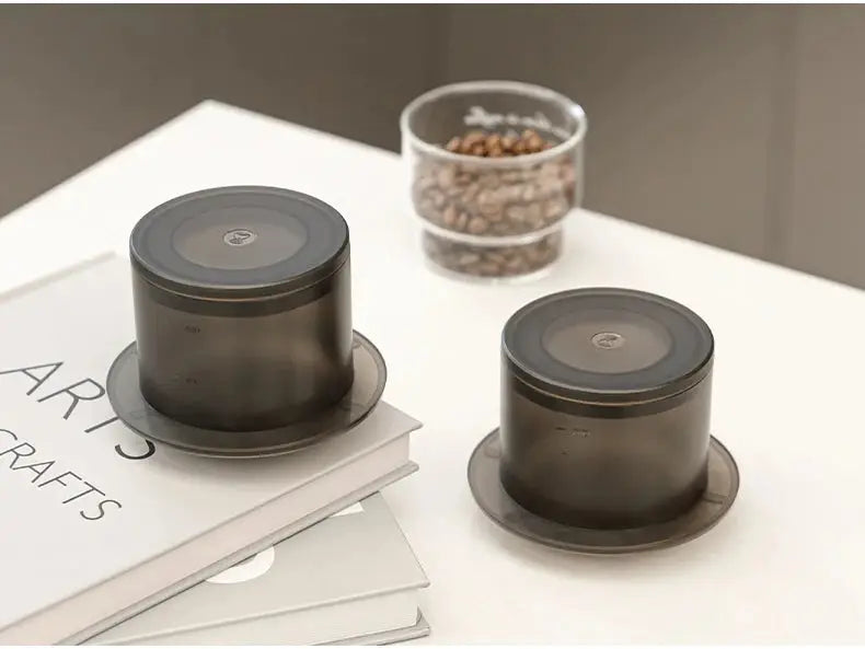 Two TIMEMORE SimpleDrip Water Droppers placed on books, showcasing their stylish and functional design for coffee lovers.