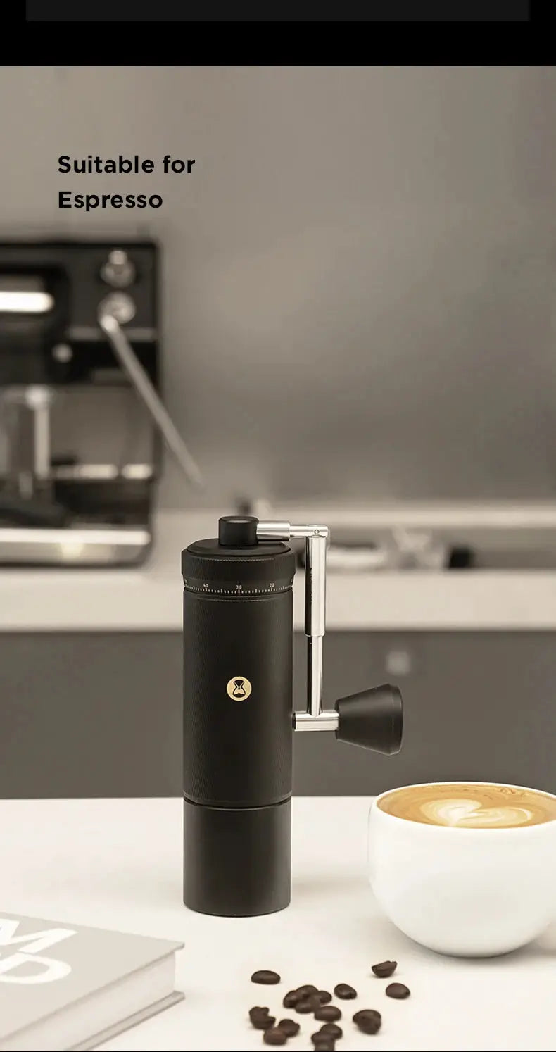 TIMEMORE CHESTNUT S3 Manual Coffee Grinder in black, featuring a sleek design with a stainless steel handle. Ideal for precision grinding, shown beside a cup of cappuccino and coffee beans in a modern kitchen setting.
