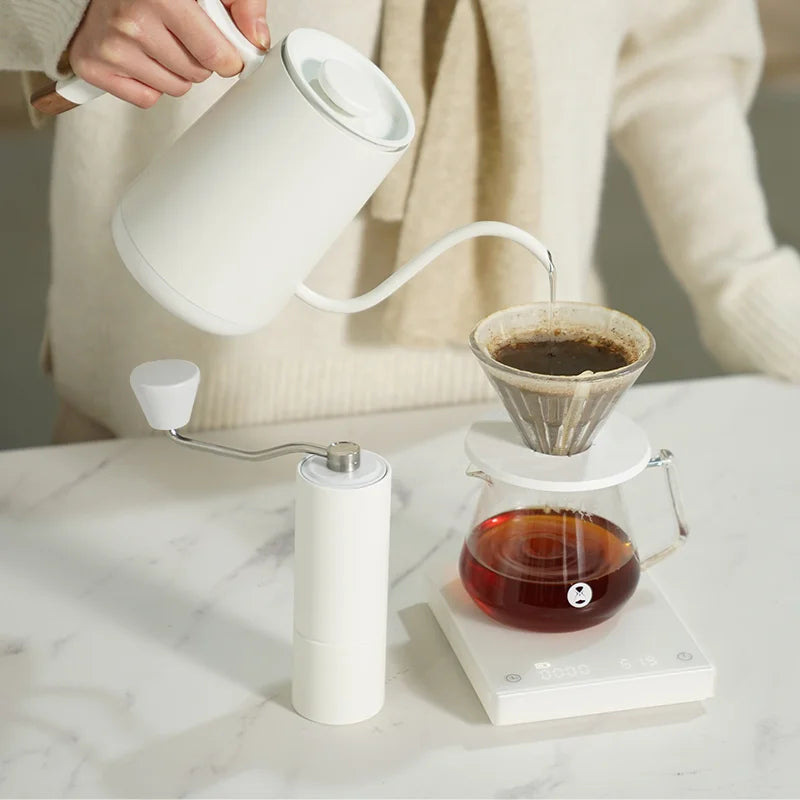 Water poured over coffee in a filter from white teapot