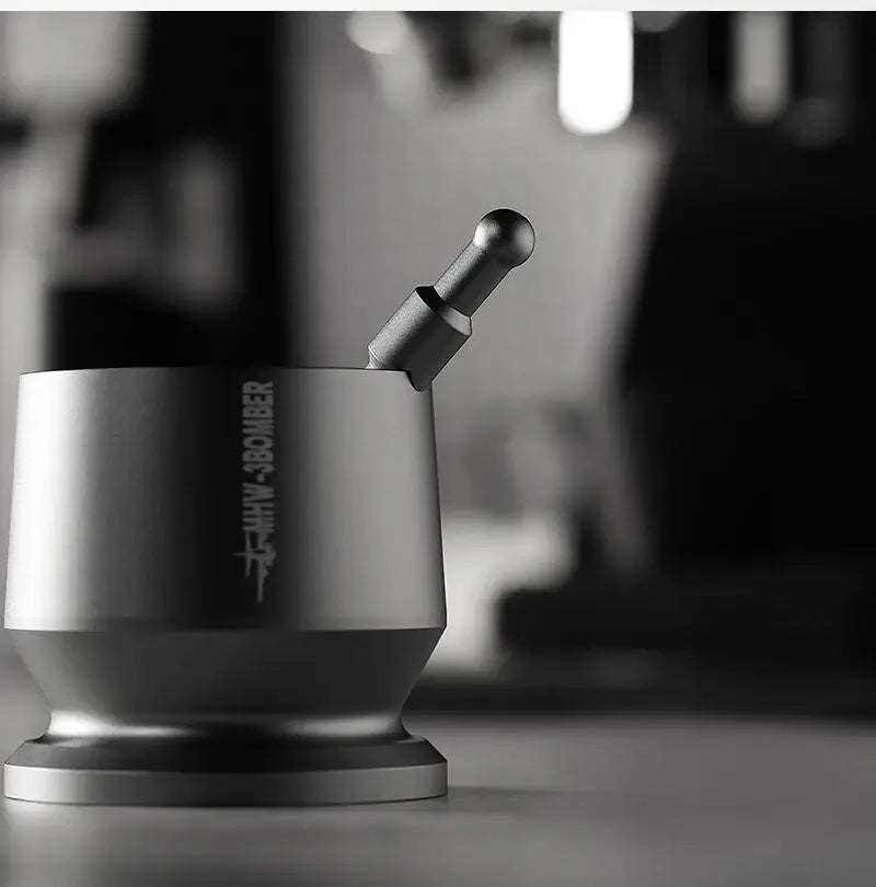 Metal coffee tamper with handle on countertop, modern espresso accessory in monochrome setting