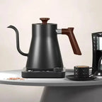 Portable gooseneck electric kettle with thermal insulation, ideal for travel. Features a sleek black stainless steel design with precise temperature control.