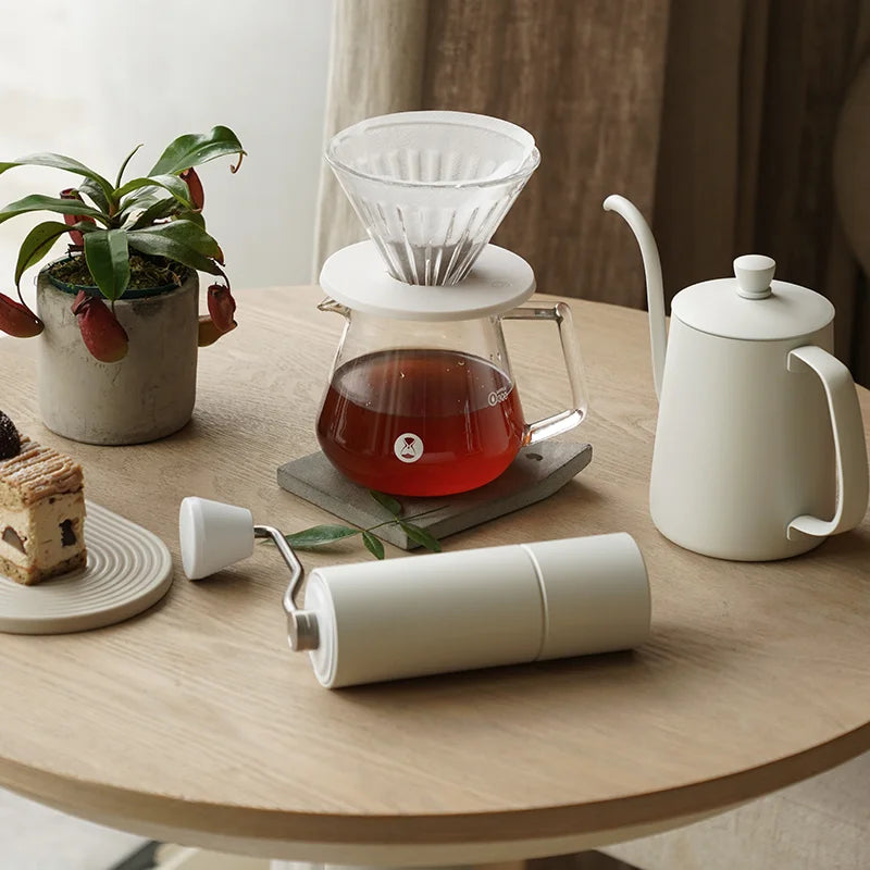 white grinder on table with teapot and filters