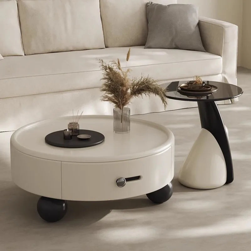 Round white coffee table with decorative items in a living room setting.