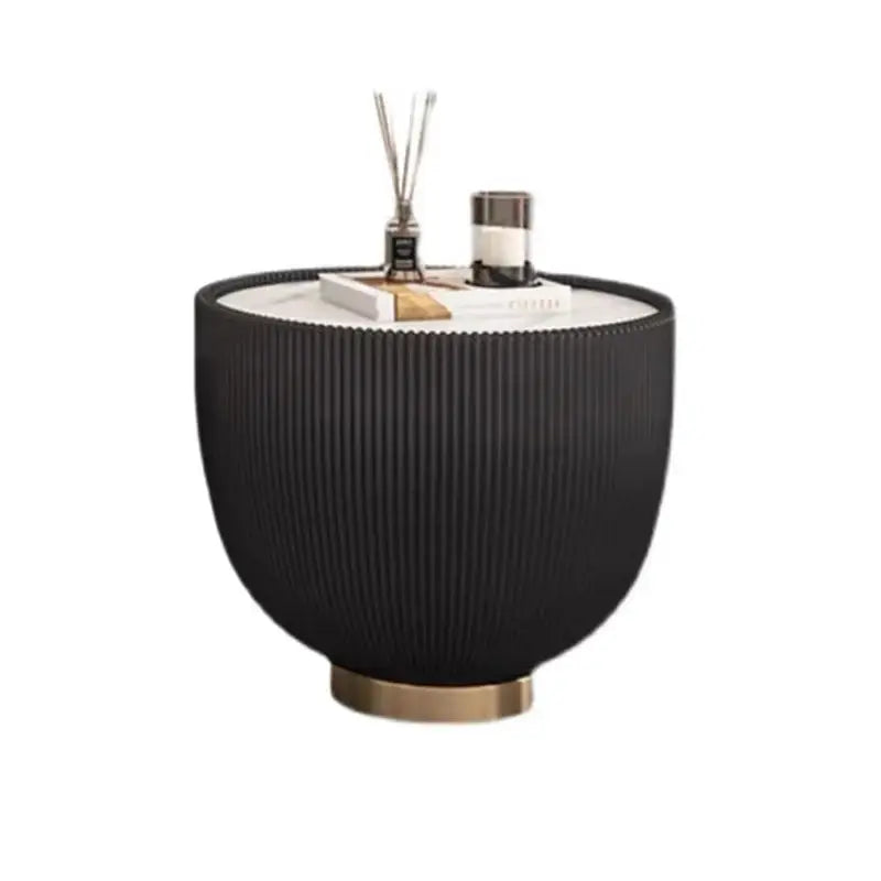 Black textured side table with decorative items on a white background