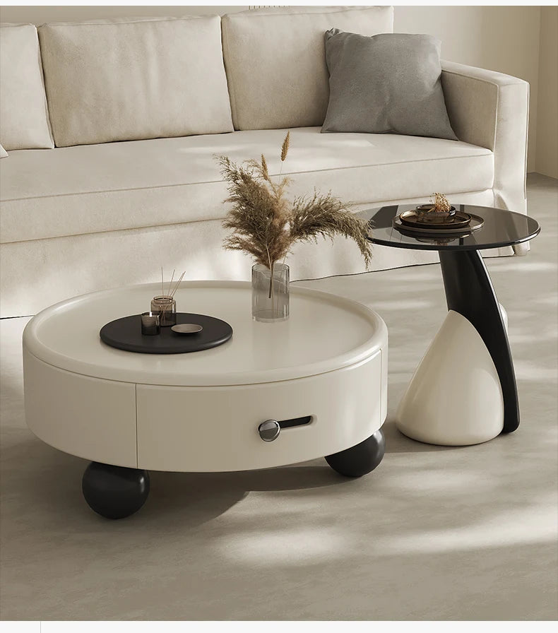 Round white coffee table with a drawer in a living room setting.