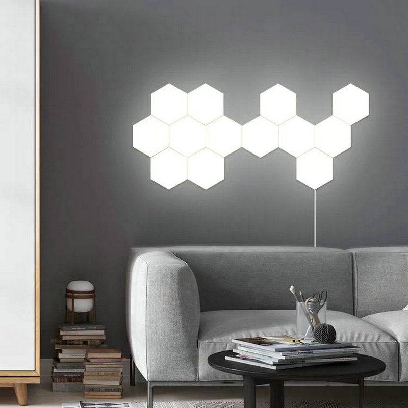 Modern white hexagonal modular LED wall light installed above a sofa. Smart wireless lighting solution for stylish home decor.