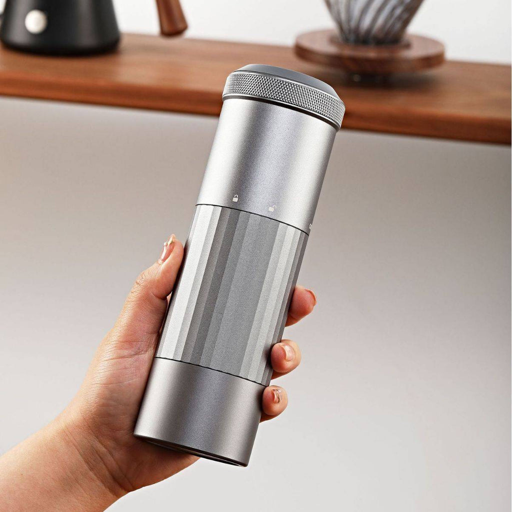 Portable Wireless Bean Grinder with sleek, minimalist design, held in hand. USB rechargeable and compact for easy coffee grinding anywhere.