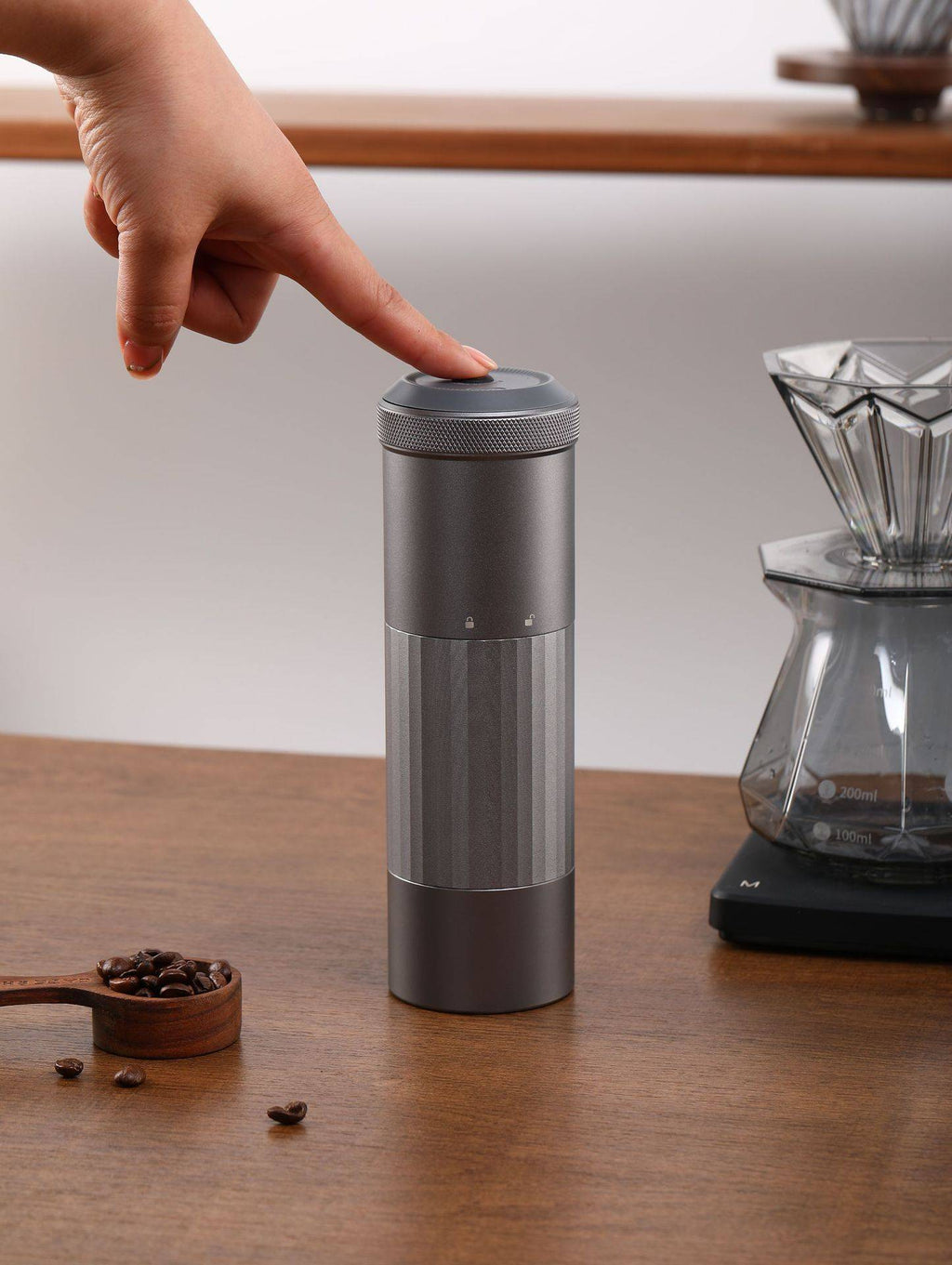 User pressing the top button of the Portable Wireless Bean Grinder. USB charging and minimalist design for easy coffee grinding.