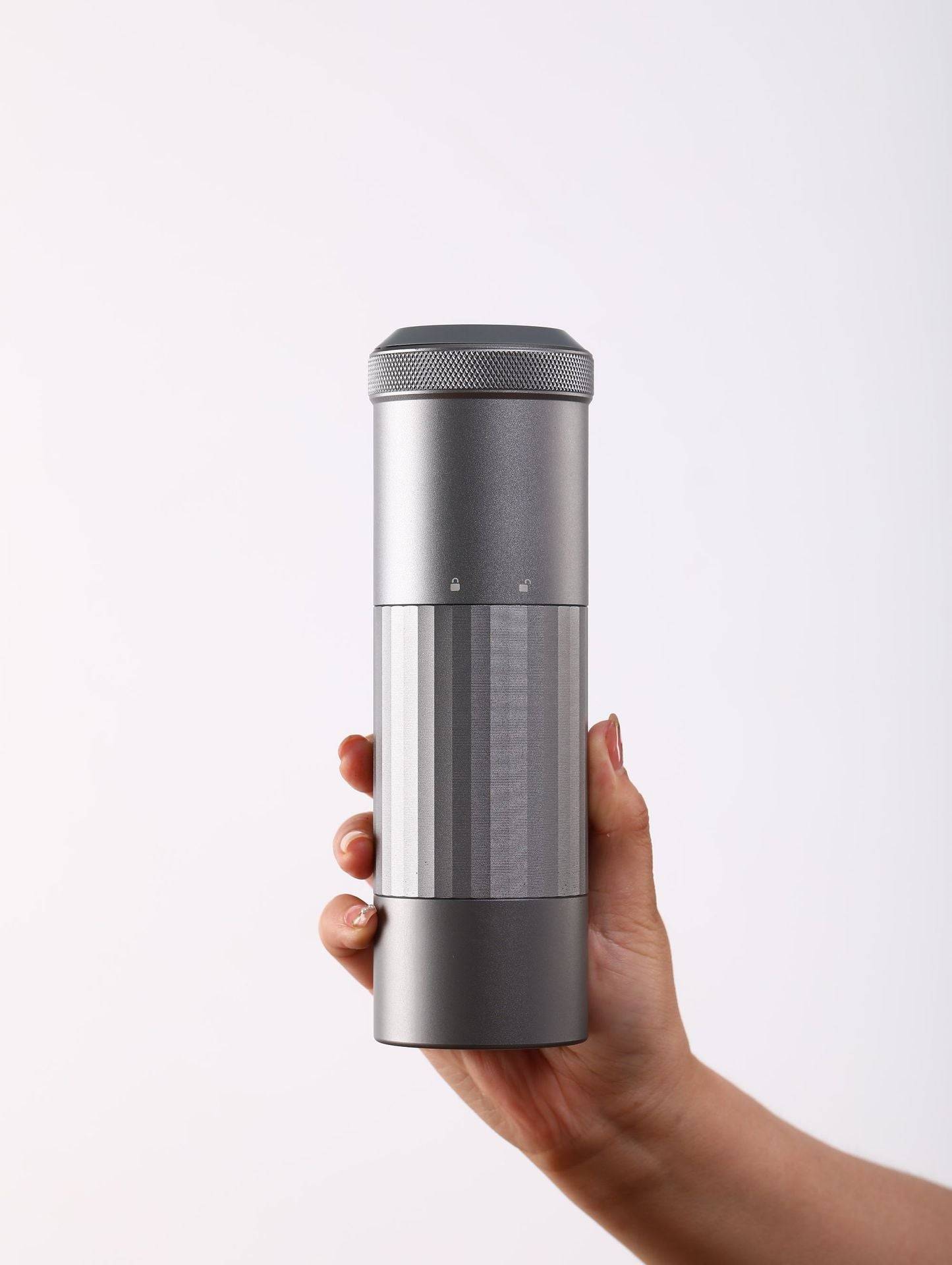 Compact and stylish Portable Wireless Bean Grinder held in hand. Features a minimalist design with USB charging for convenient coffee grinding.
