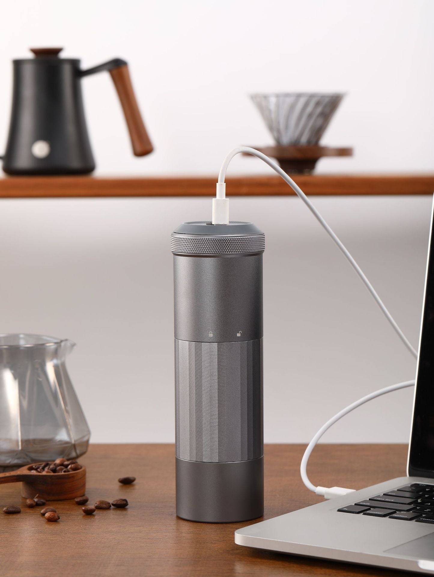 Portable Wireless Bean Grinder connected to a laptop via USB charging. Compact and efficient for fresh coffee grinding anywhere.